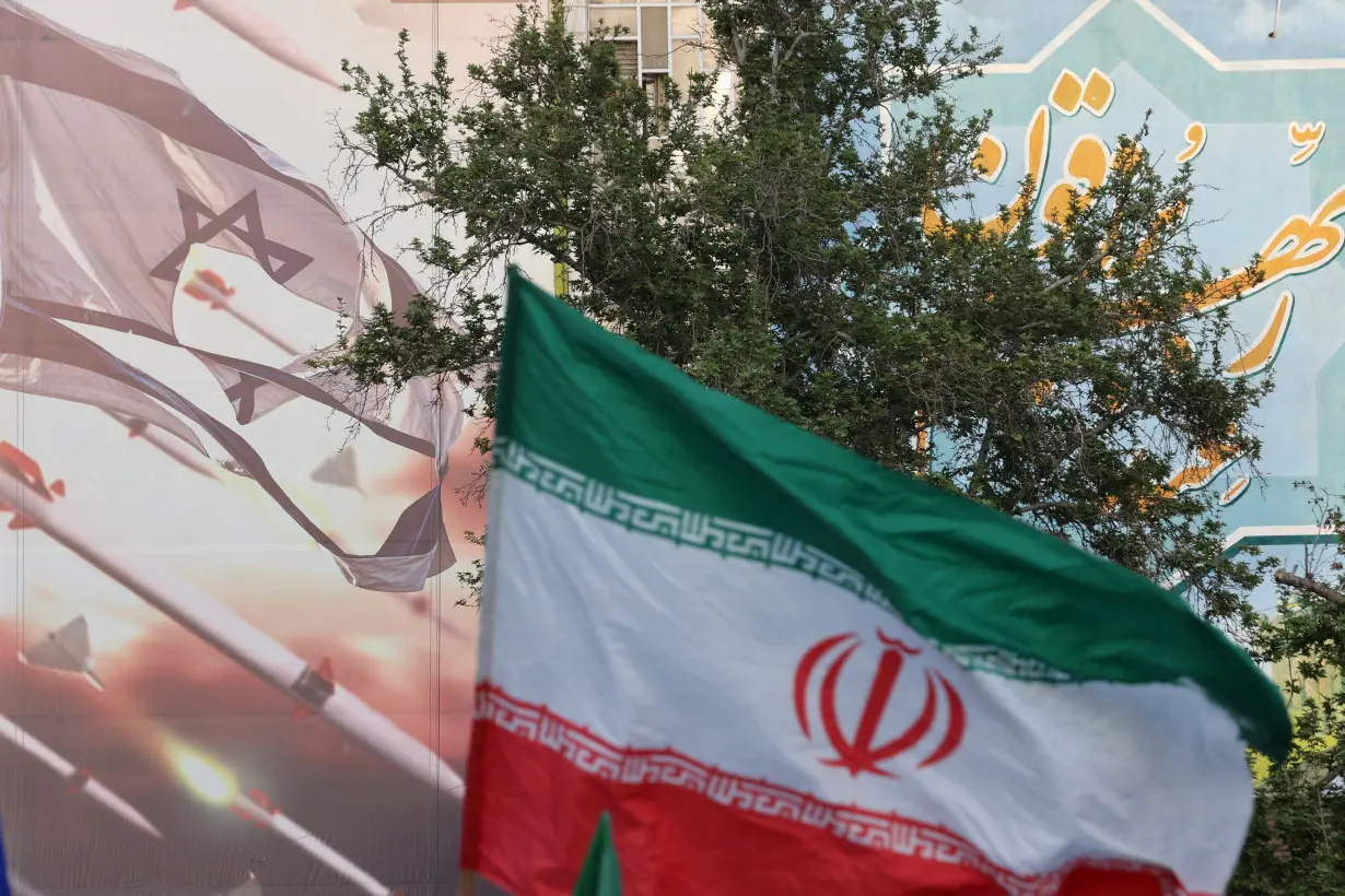 FILE PHOTO: An anti-Israel billboard is seen next to the Iranian flag during a celebration following the IRGC attack on Israel, in Tehran