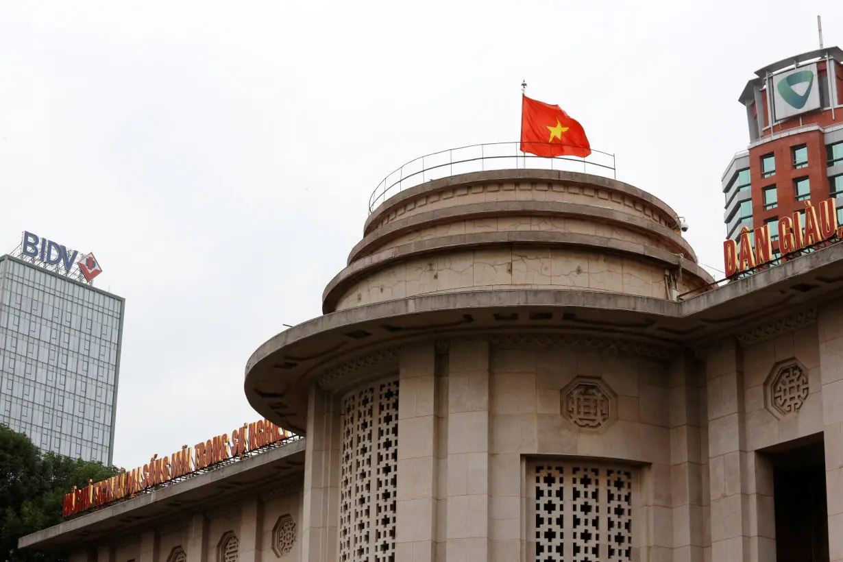 A Vietnamese flag flies atop the State Bank building in central Hanoi