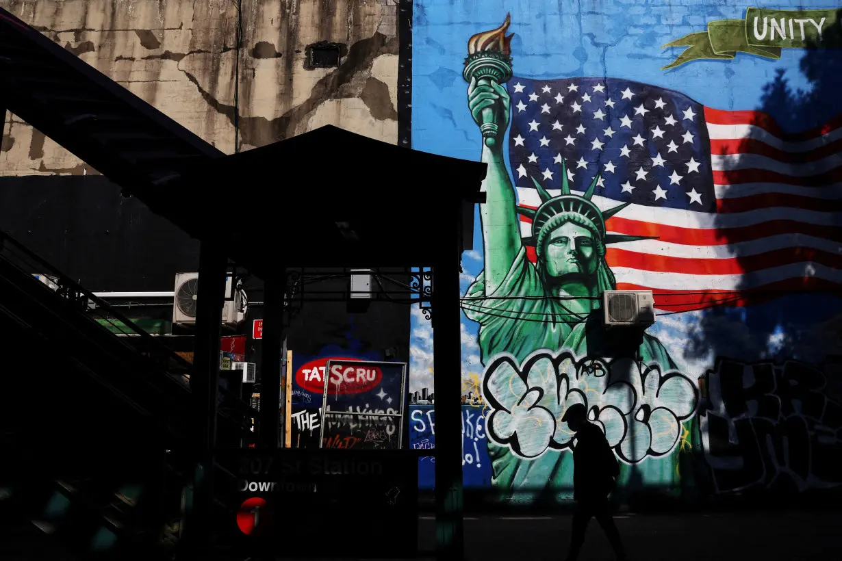 FILE PHOTO: A man walks in silhouette past the 207th Street subway station entrance in the Inwood neighborhood in New York City