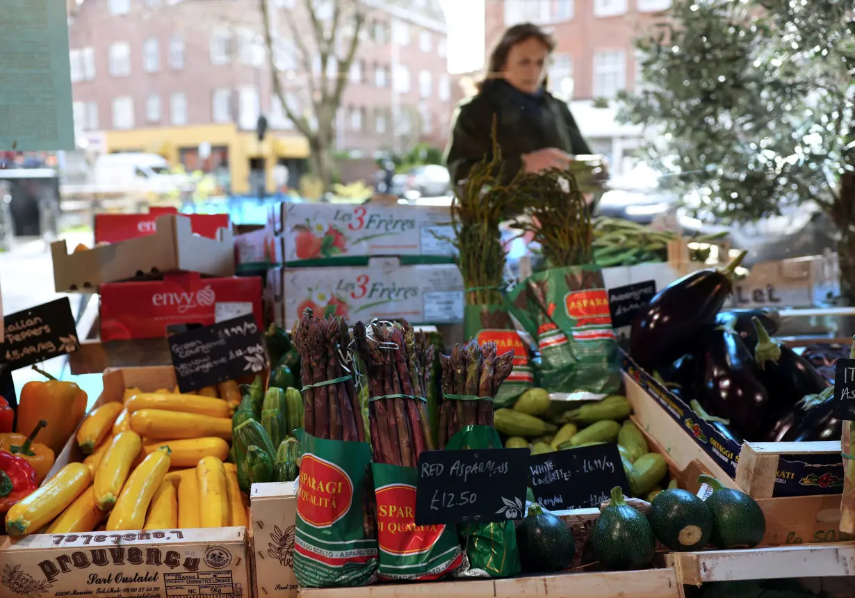 A customer shops for vegetables at gourmet grocery store Andreas, in London