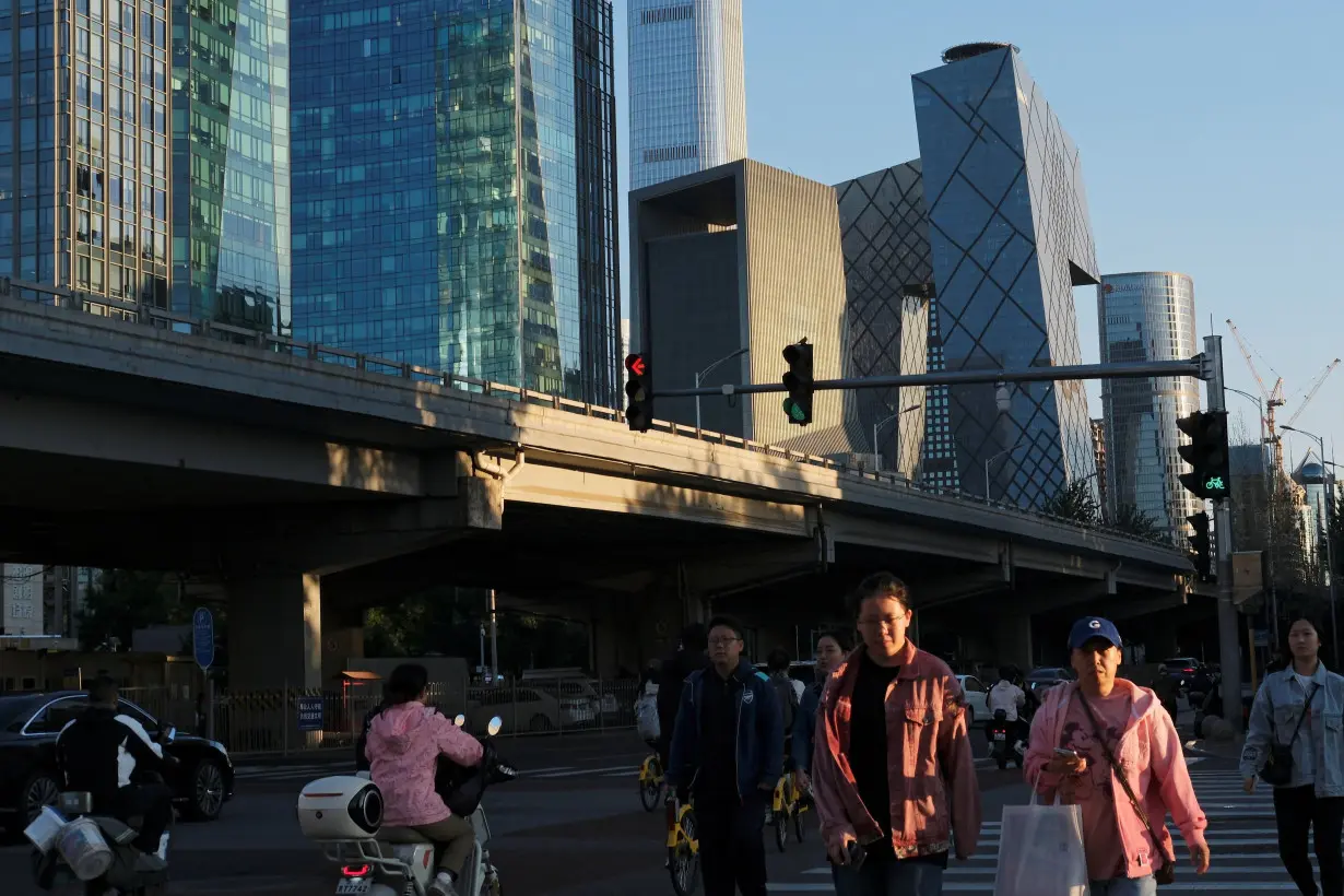 People cross an intersection near the central business district in Beijing