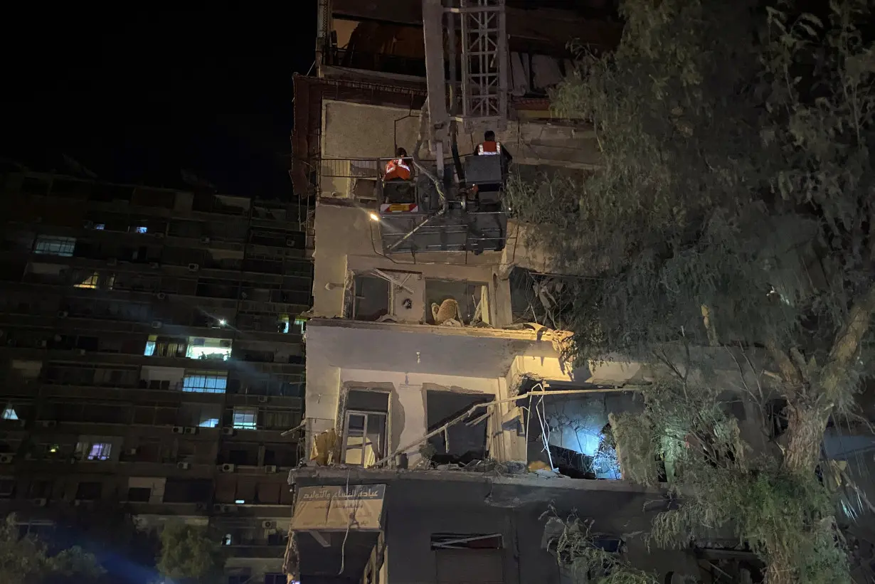 Rescuers work at the site of an Israeli airstrike that targeted a residential building in the Mezzah suburb, in Damascus