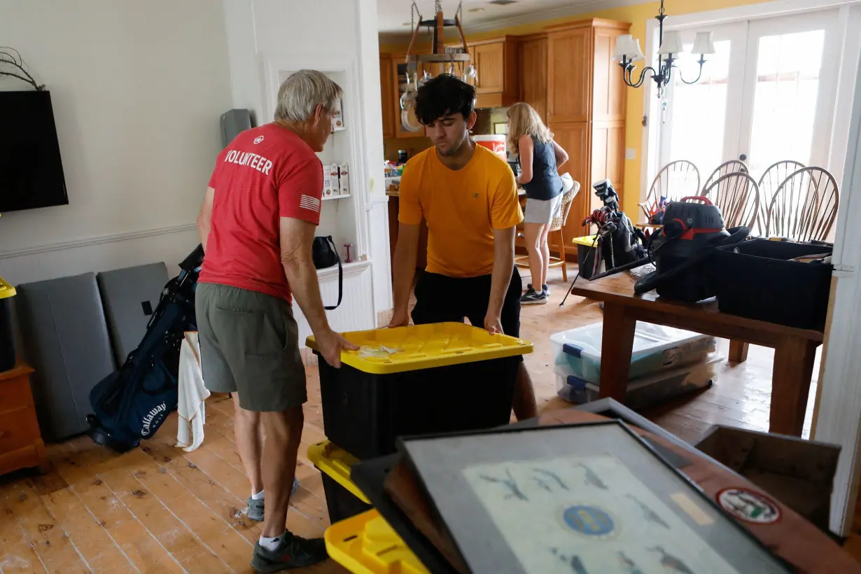 Rich Lorenzen and his son Sam Grande carry their belongings as they prepare to evacuate their home before the arrival of Hurricane Milton, St. Pete Beach, Florida, on October 7.