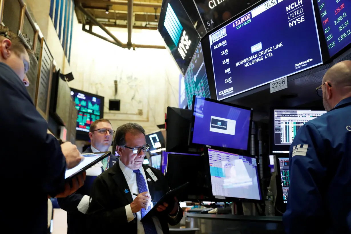 Traders wait for stocks to resume trading on Norwegian Cruise Lines Holding Ltd. on the floor of the New York Stock Exchange in New York