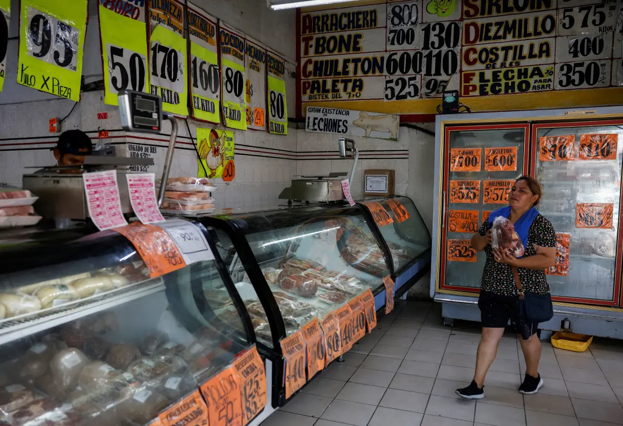 A woman carries a package of meat in a butcher's shop, in Monterrey