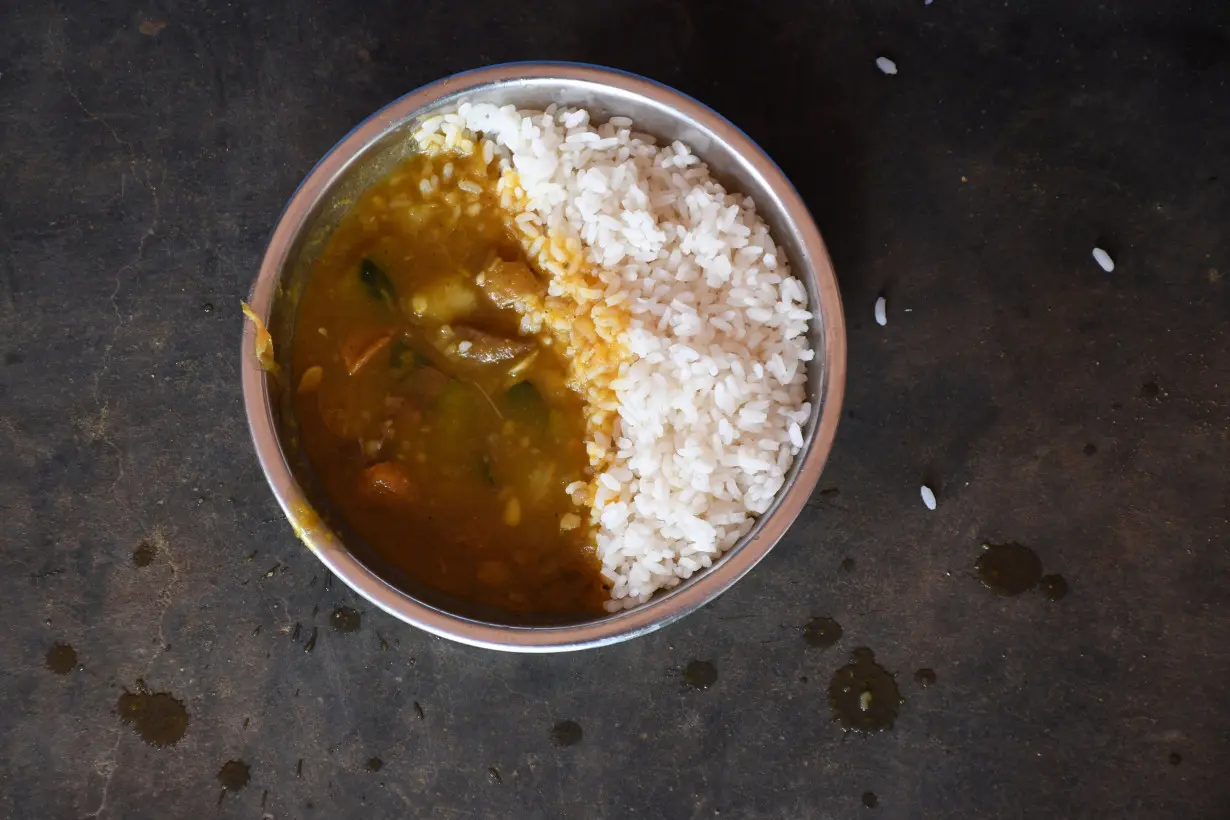 A plate of a lunch meal lies on the floor before it is served to a child at government-run upper primary school in Ghugudipada village