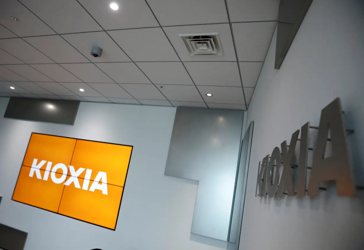 FILE PHOTO: Japanese chipmaker Kioxia's logo and promotional video on a screen are pictured at its headquarters in Tokyo