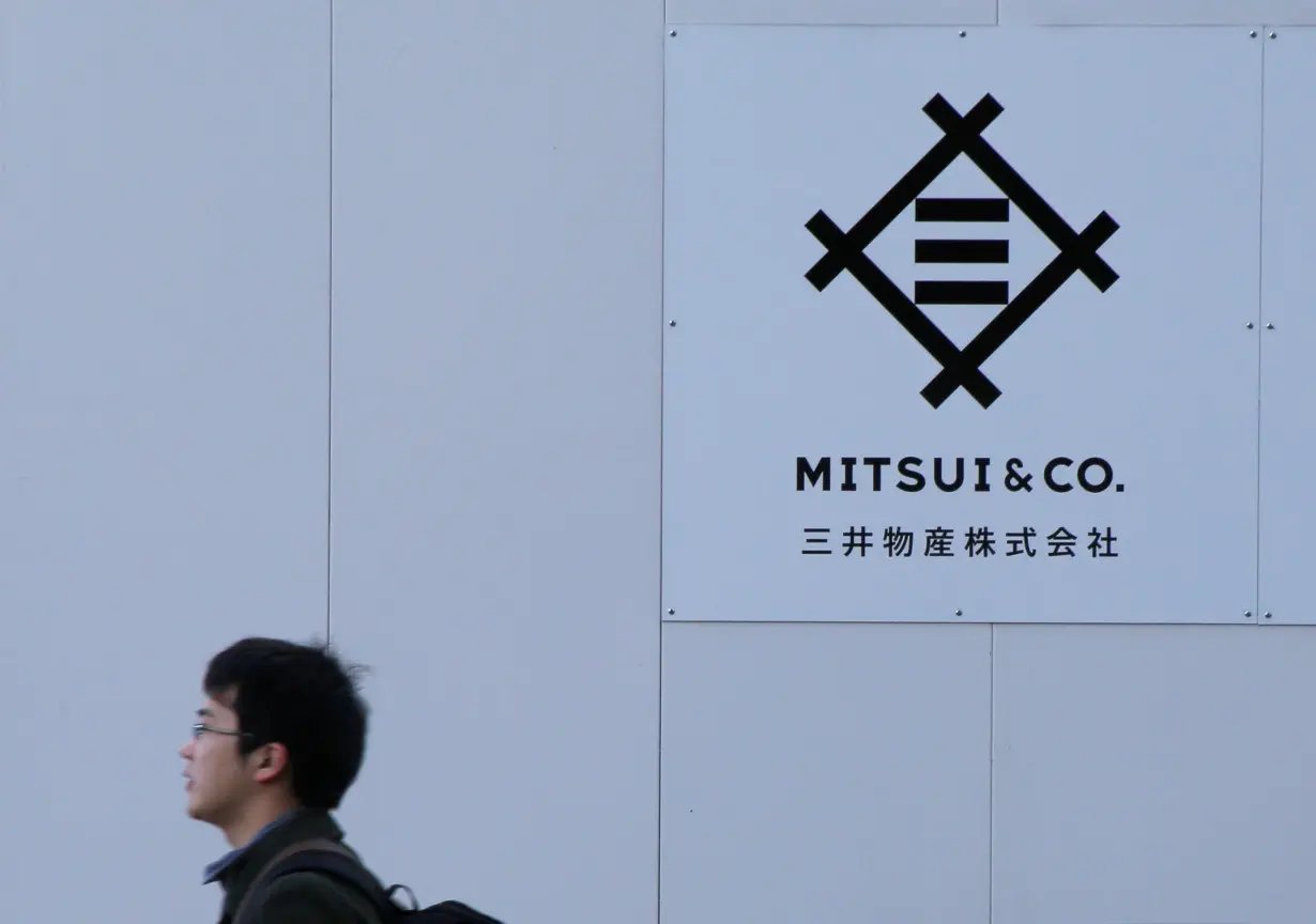 Man walks past the logo of Japanese trading company Mitsui & Co. in Tokyo