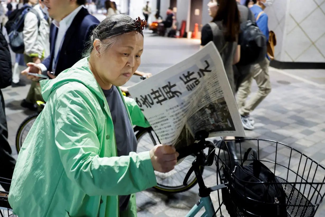 People react as they receive an extra edition of Yomiuri Newspaper about Japanese organisation Nihon Hidankyo, which won the Nobel Peace Prize in Tokyo