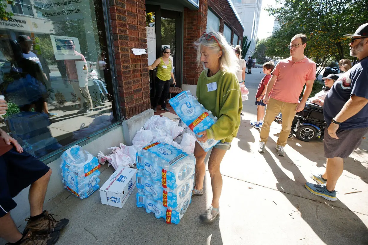 Volunteers and local government employees handle bottles of water before distributing them to residents in Asheville on October 2.