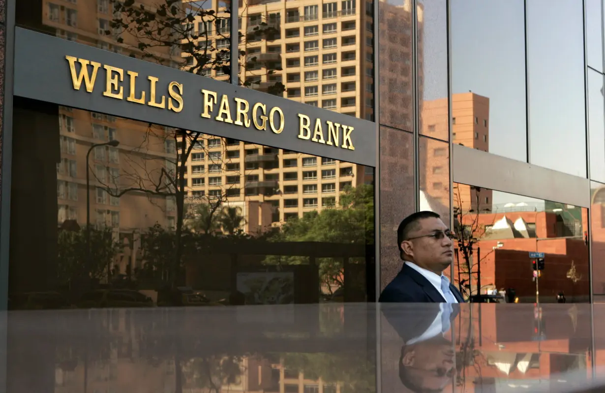 FILE PHOTO: Man stands outside Wells Fargo bank building in Los Angeles