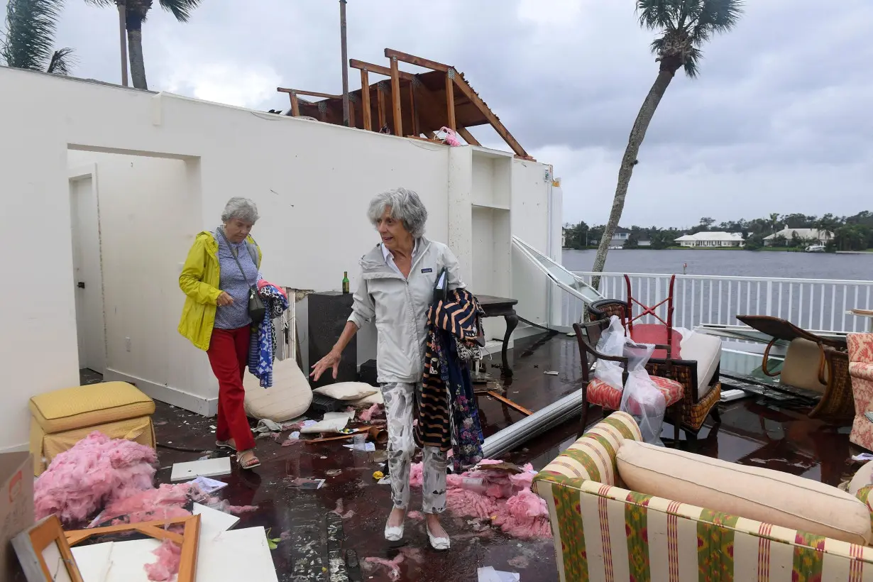 Bayou West resident Mary Singer, 82, and friend Brita Gwynn, 84, try to salvage items from Singer's second floor home after an apparent tornado touched down on the central beach community, leaving a path of destruction after Hurricane Milton in Vero Beach, Florida on October 11.