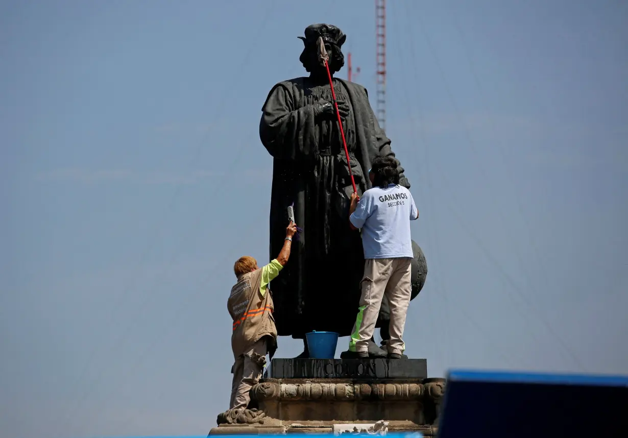 FILE PHOTO: Workers clean the statue of Italian explorer Cristobal Colon, also known as Christopher Columbus, in Mexico City