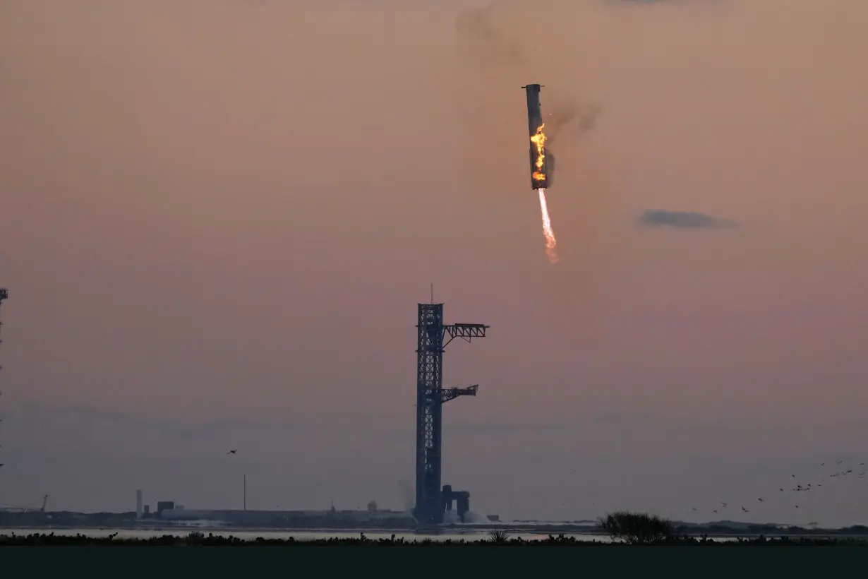 SpaceX's Super Heavy rocket booster returns to the launchpad to be captured by Mechazilla's 