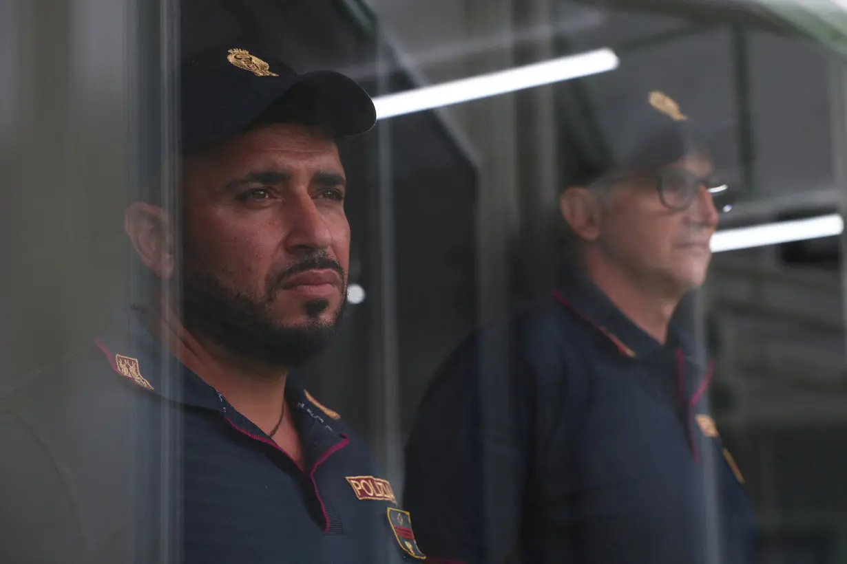 FILE PHOTO: Italian police officers stand inside the reception camp at the port where Italy will process illegal migrants