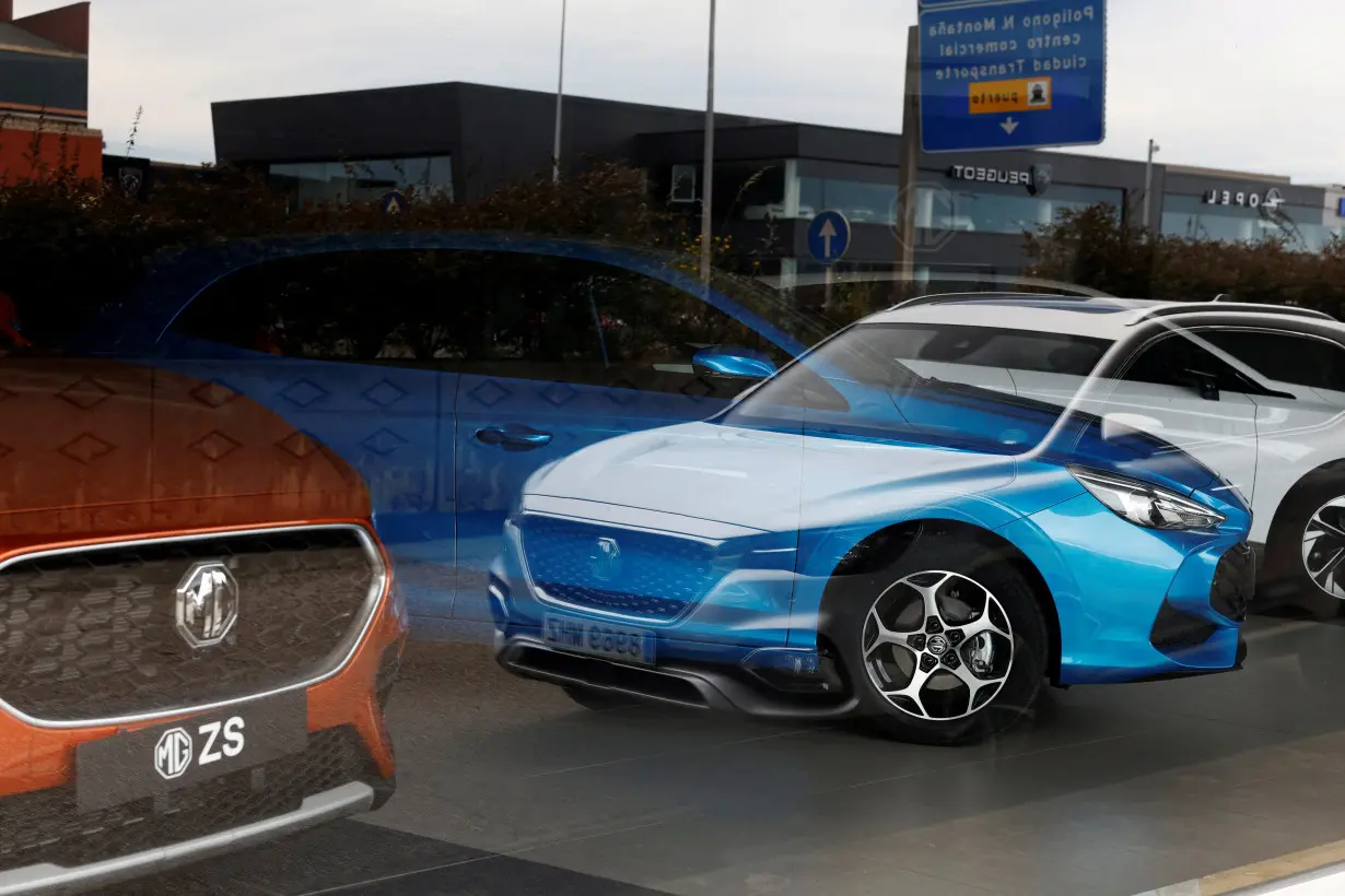 MG Motor vehicles are seen reflected in the glass of a car showroom in Santander,