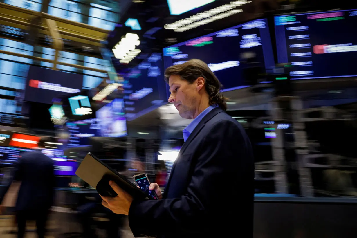 FILE PHOTO: Traders work on the floor of the NYSE in New York