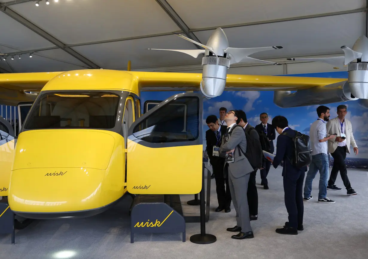 Attendees view a Wisk autonomous electric air taxi at Farnborough International Airshow, in Farnborough