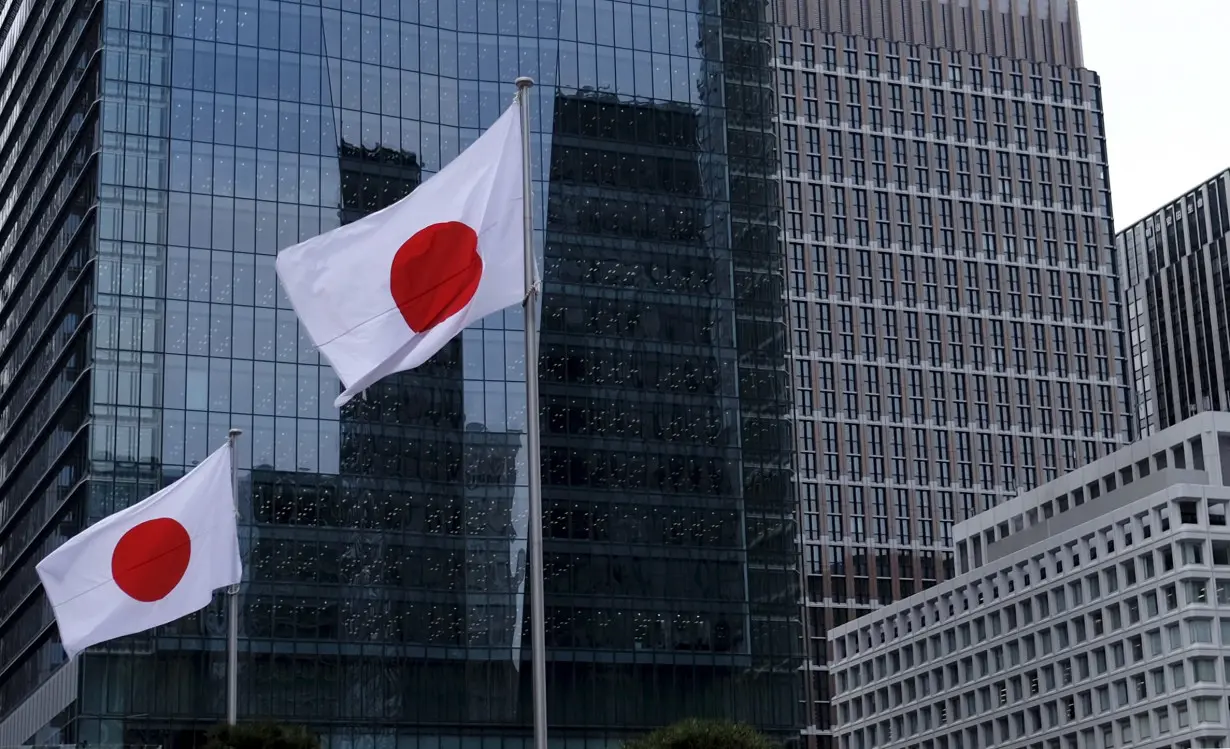 Japanese national flags flutter in front of buildings at Tokyo's business district