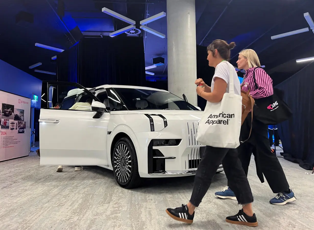 People walk in front of a Zeekr 009 model electric vehicle (EV) being showcased at SXSW Sydney