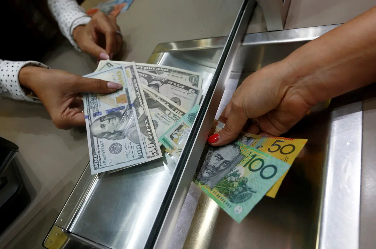 FILE PHOTO: Australian dollar and U.S. dollar denominations are shown in a photo illustration at a currency exchange in Sydney