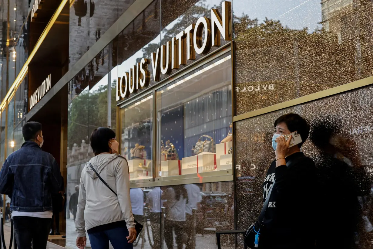 FILE PHOTO: People walk past a Louis Vuitton store in Tsim Sha Tsui, a bustling shopping hotspot, in Hong Kong