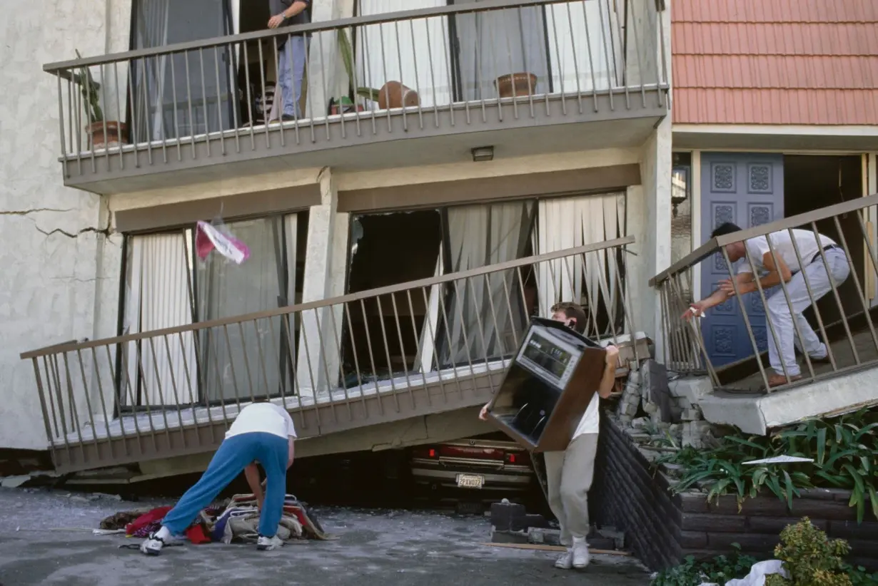 Residents clean up in the Van Nuys neighborhood following the 1994 Northridge earthquake in Los Angeles on January 17, 1994.