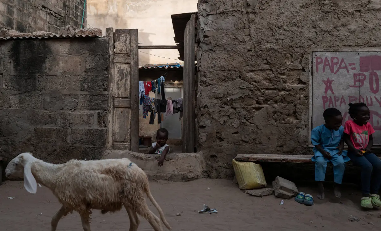 A child observes at the entrance of his family house on the outskirts of Dakar