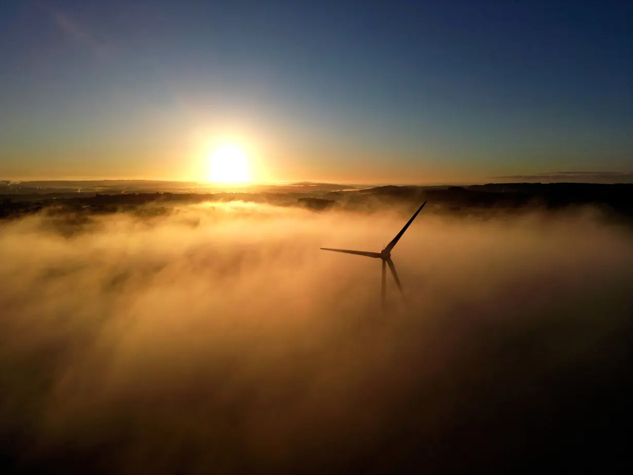 FILE PHOTO: A wind turbine is shrouded in fog at the Low Carbon Energy Generation Park on the Keele University campus