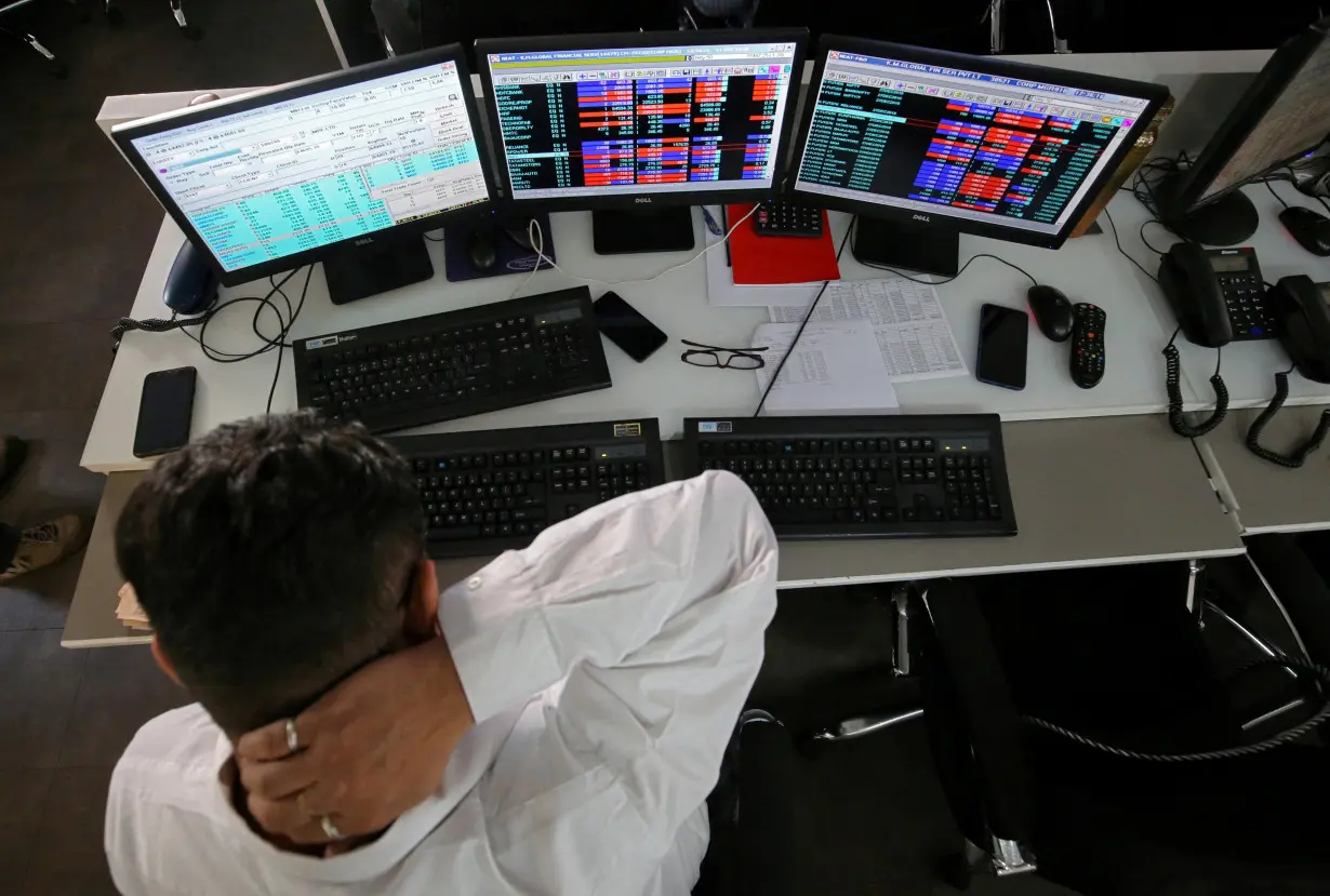 FILE PHOTO: A broker reacts while trading at his computer terminal at a stock brokerage firm in Mumbai