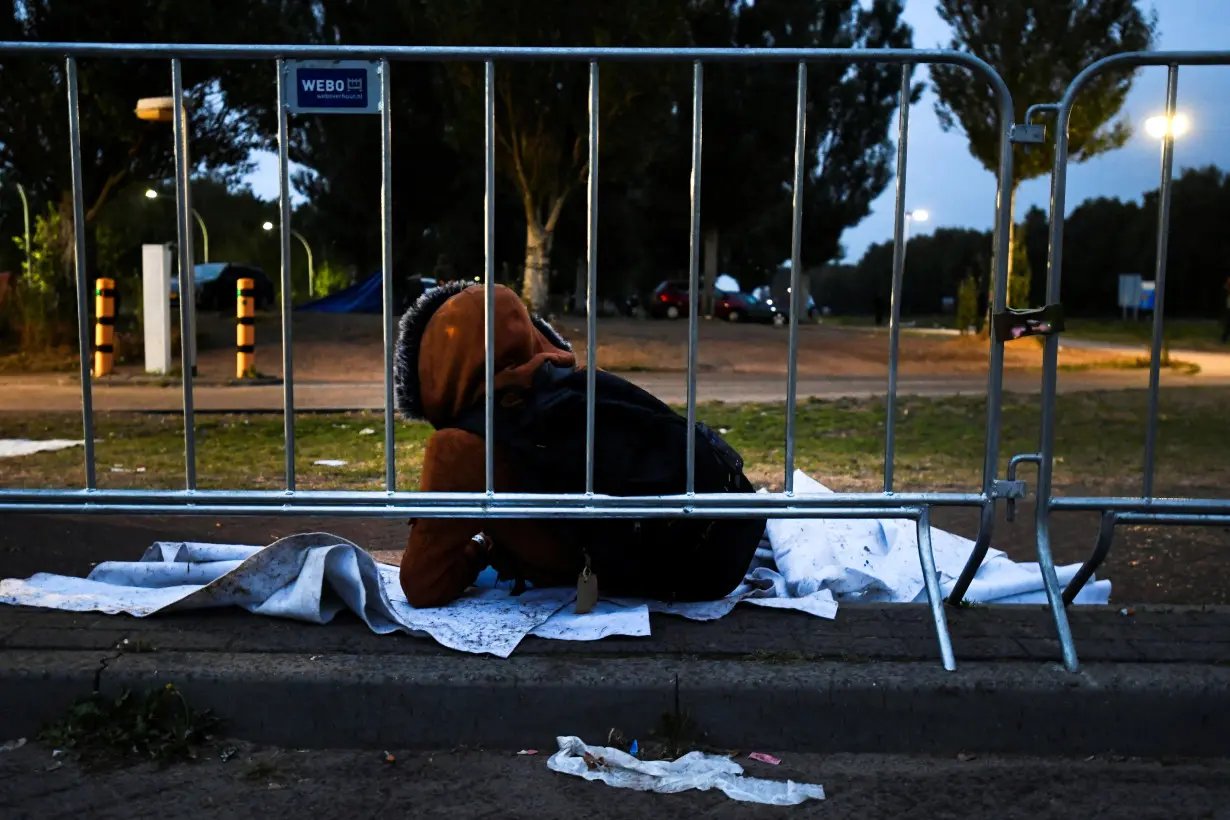 Refugees wait outside at the main reception centre for asylum seekers, in Ter Apel