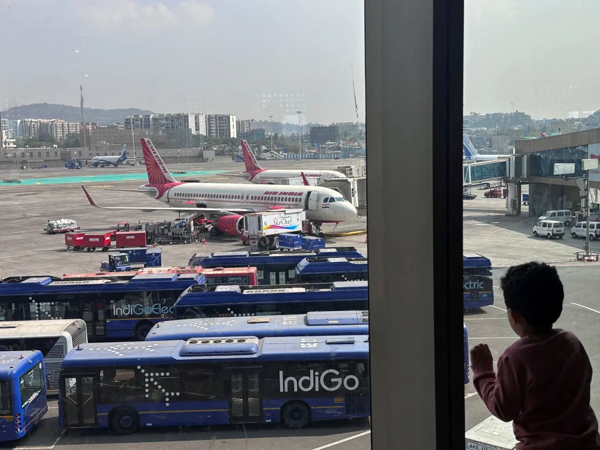 FILE PHOTO: A boy looks at Air India airline passenger aircrafts parked at the Chhatrapati Shivaji Maharaj International Airport in Mumbai