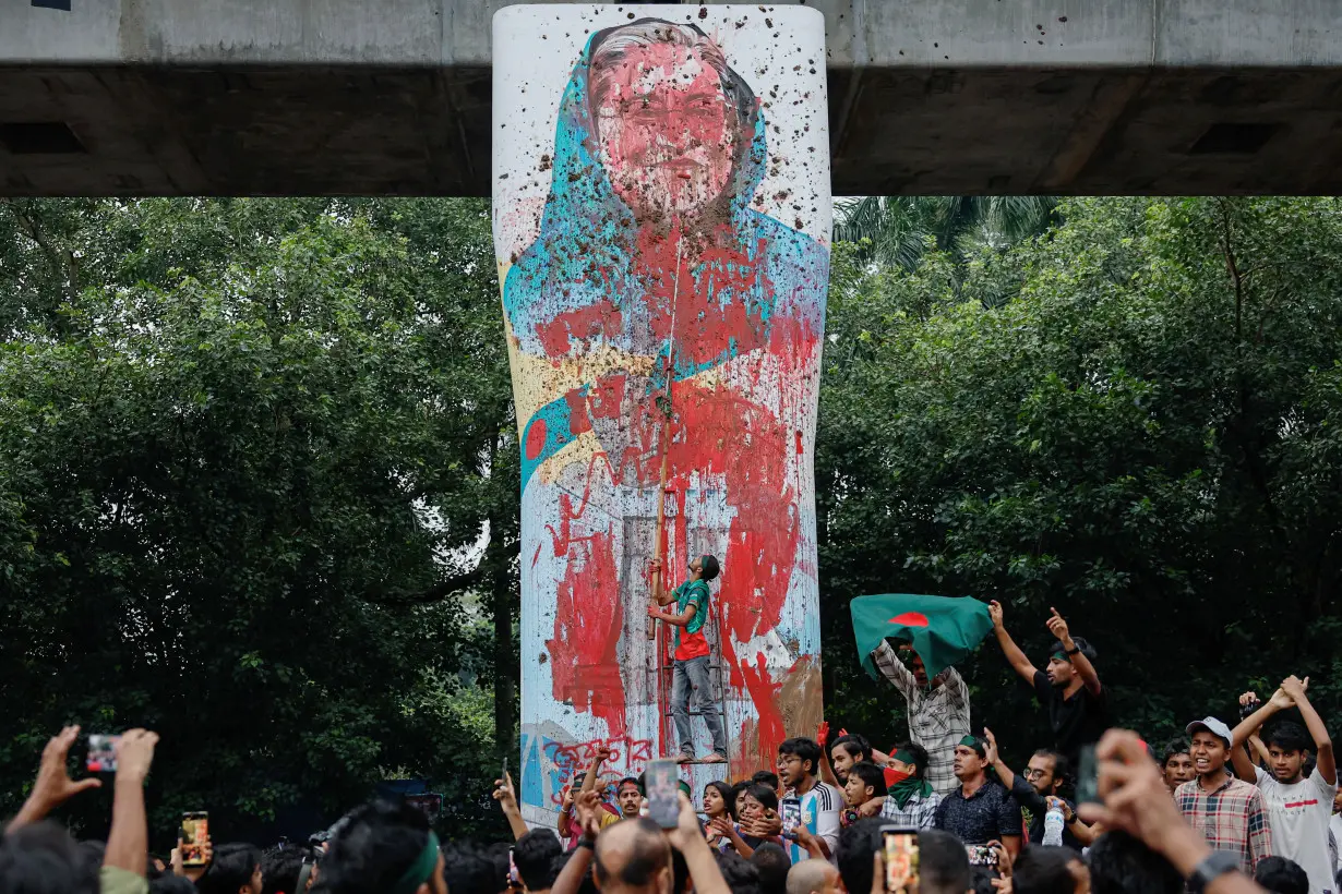 Protesters shout slogans as they vandalise a mural of Bangladeshi PM Hasina with paint and mud, demanding her resignation at TSC area of University of Dhaka