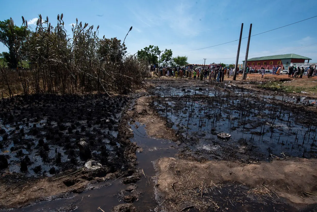 People gather at the scene of a fuel tanker explosion in Majiya town, Nigeria, on October 16.