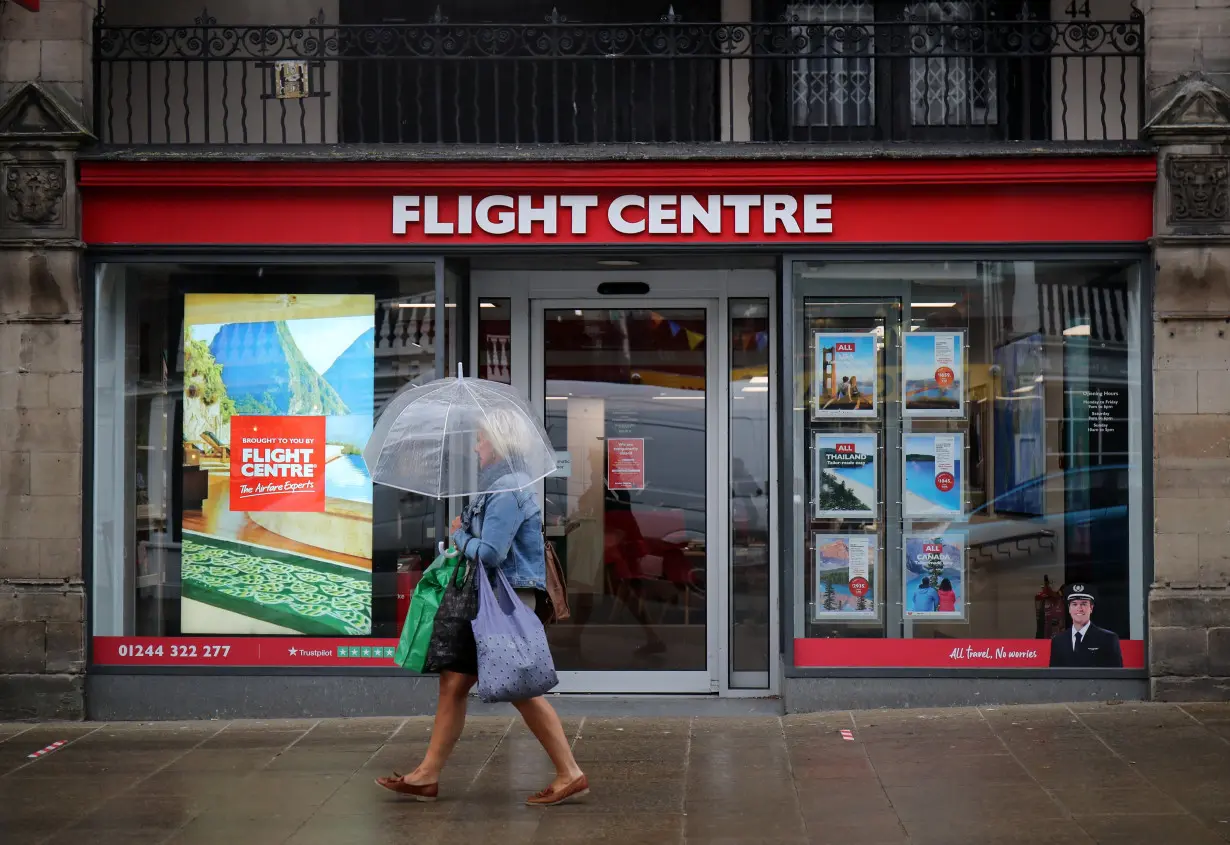 A woman walks past a Flight Centre travel agency in Chester