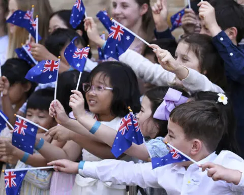 Children greet King Charles III and Queen Camilla outside a Sydney church