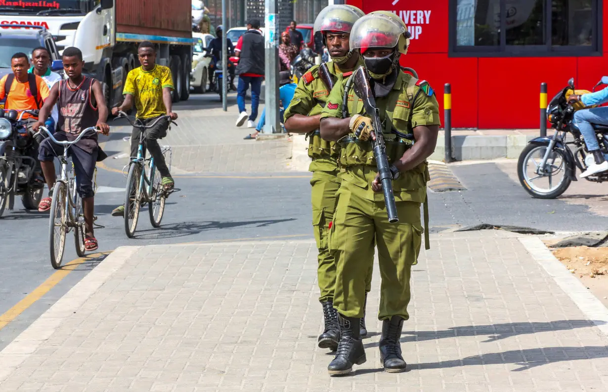 Tanzania riot police officers walk during the protests to condemn a series of kidnappings and murders in Dar es Salaam