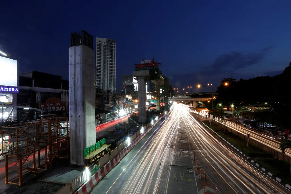 Cars pass Skytrain construction site in Bangkok