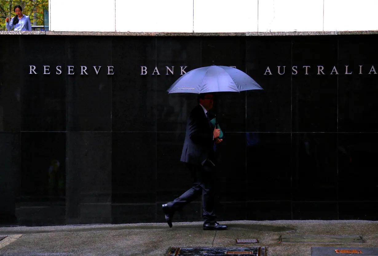 Pedestrians walk past the Reserve Bank of Australia building in central Sydney, Australia