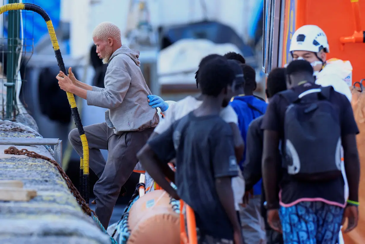 A migrant disembarks from a Spanish coast guard vessel, in the port of Arguineguin