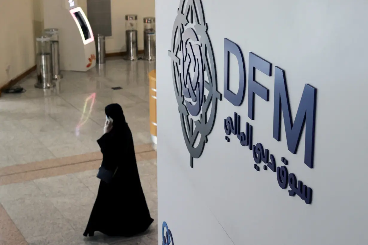 A woman walks through the Dubai Financial Market in Dubai