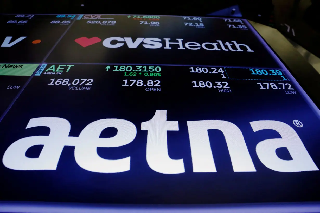 FILE PHOTO: Logos of CVS and Aetna are displayed on a monitor above the floor of the New York Stock Exchange shortly after the opening bell in New York