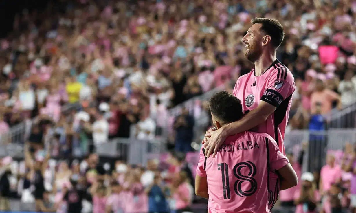 Messi celebrates his first goal with teammate Jordi Alba.