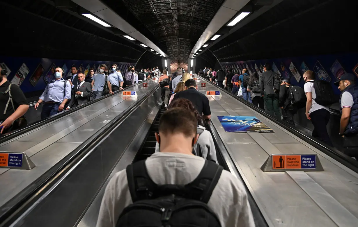 FILE PHOTO: Workers travel through London Bridge rail and underground station during the morning rush hour in London