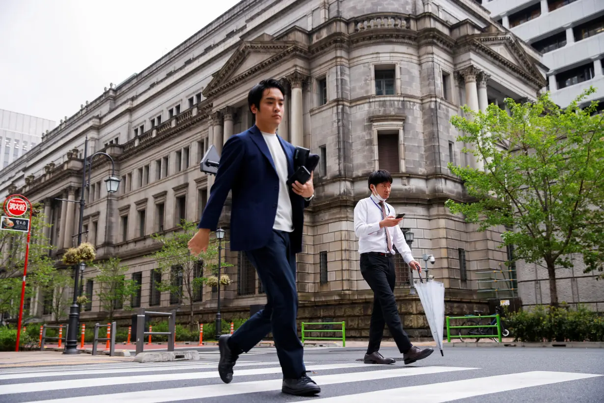 People walk in front of the bank of Japan building in Tokyo