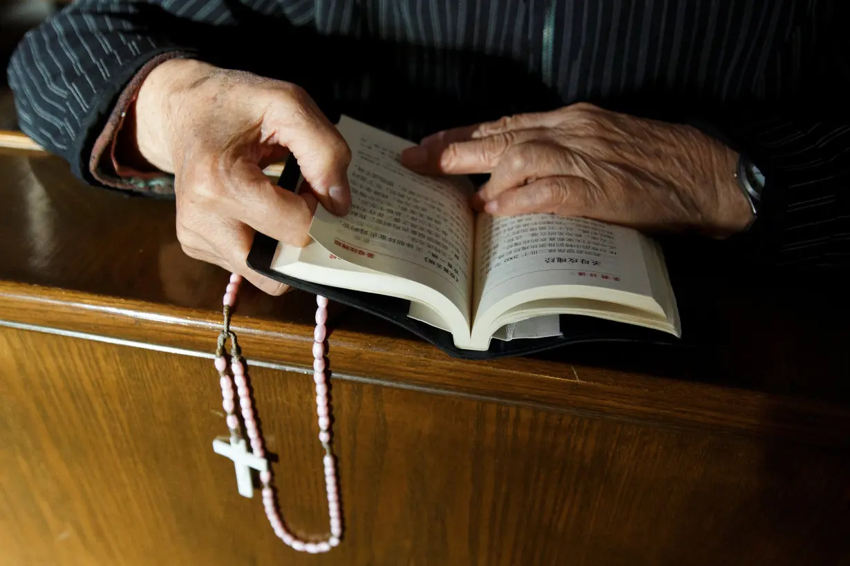 A believer reads the bible during mass at government-sanctioned St. Joseph's Church in Beijing