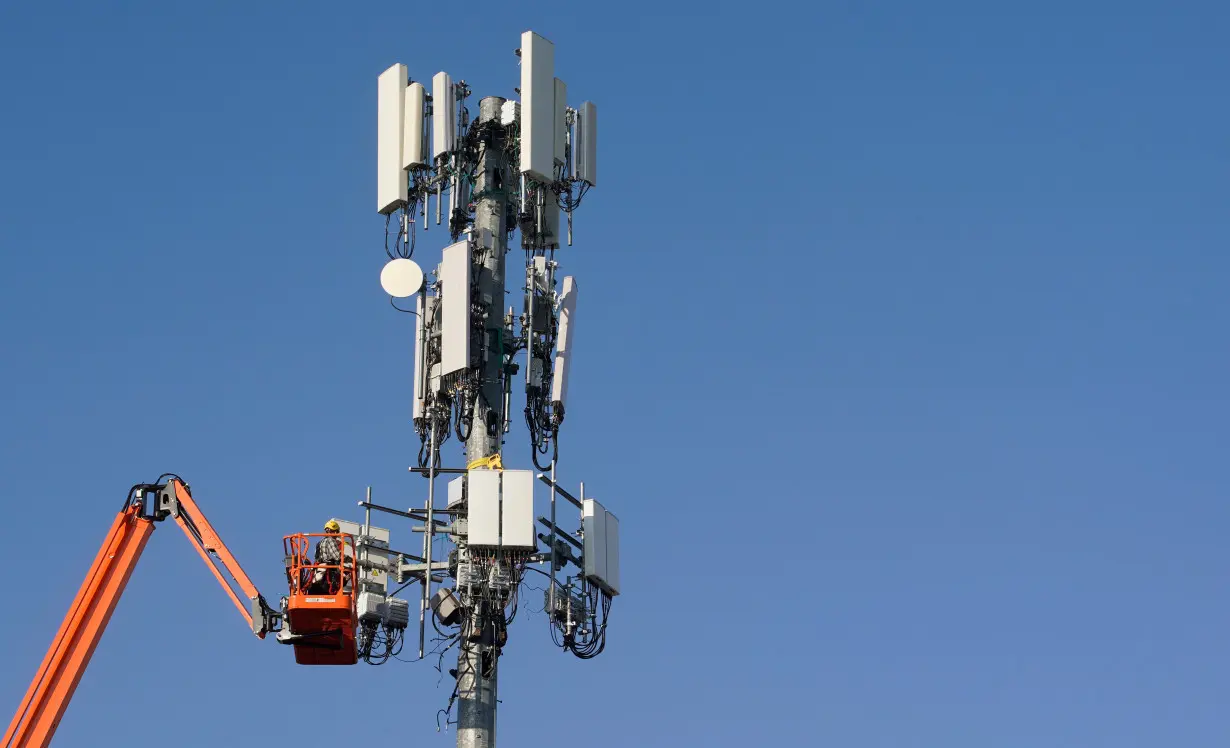 A contract crew from Verizon installs 5G equipment on a tower in Orem