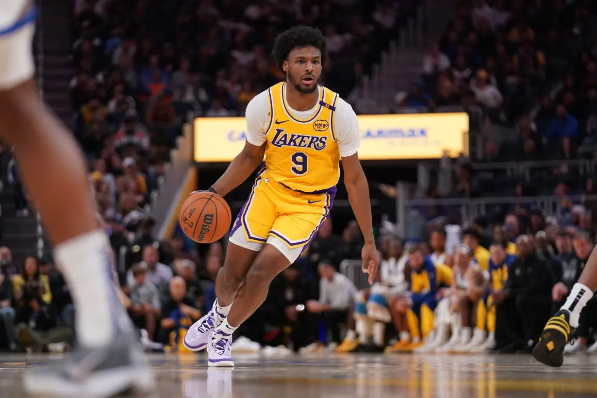 Lakers guard Bronny James dribbles the ball against the Golden State Warriors in the preseason.