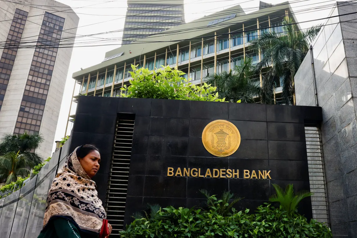 A woman passes by Bangladesh's central bank in Dhaka