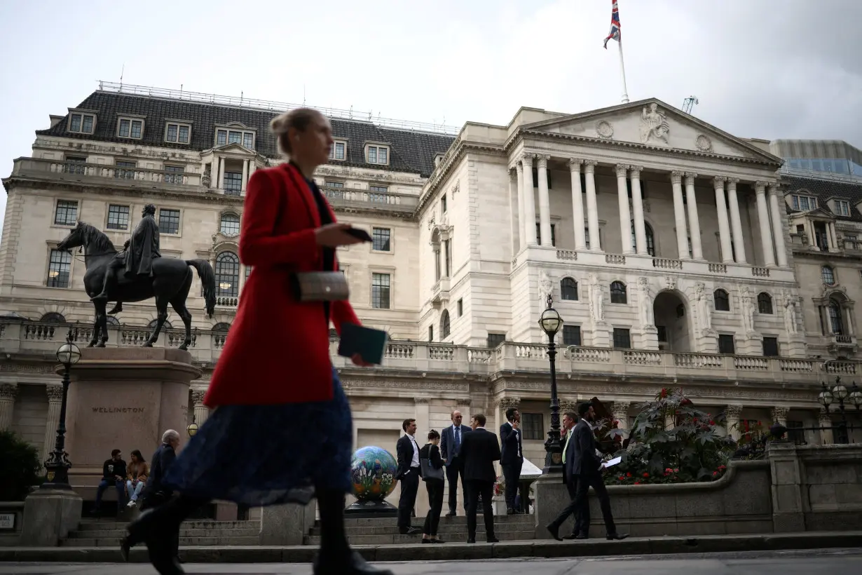 FILE PHOTO: People stand outside the Bank of England in the City of London financial in London